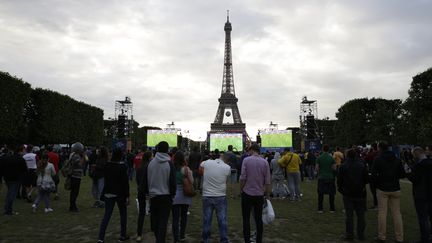 Des supporters regardent un match de l'Euro sur la "fan zone" située&nbsp;près de la tour Eiffel, le 13 juin 2016, à Paris. (THOMAS SAMSON / AFP)