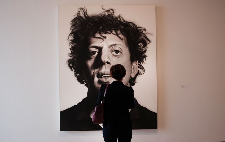 Une femme observe "Phil" tableau réalisé par Chuck Close en 1969, qui représente son ami, le compositeur&nbsp;Philip Glass. Exposition au&nbsp;Whitney Museum of American Art&nbsp;à New York, le 23 avril 2015 (SPENCER PLATT / GETTY IMAGES NORTH AMERICA)