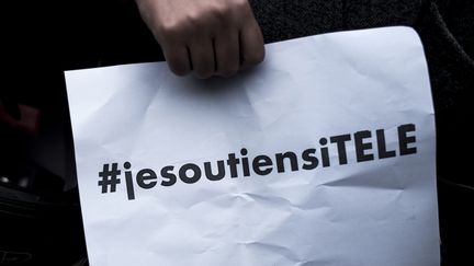 Un manifestant tient une pancarte de soutien à la chaîne d'information en continu i-Télé, le 19 octobre 2016 lors d'un rassemblement à&nbsp;Boulogne-Billancourt (Hauts-de-Seine). (PHILIPPE LOPEZ / AFP)