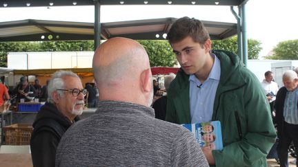 Guilhem Carayon, candidat LR/RN sur la 3e circonscription du Tarn, en campagne sur le marché d'Aussillon, le 20 juin 2024. (CLEMENT PARROT / FRANCEINFO)