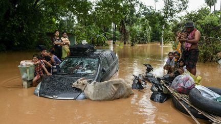 Des habitants de Taungoo, dans la région de Bago, en Birmanie, dans une rue inondée, le 14 septembre 2024. (SAI AUNG MAIN / AFP)