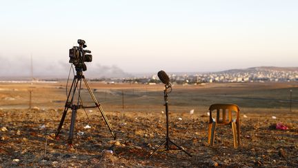 Une cam&eacute;ra et un micro sont install&eacute;s en face d'une colline de Kobani, en Syrie, le 24 octobre 2014, &agrave; la fronti&egrave;re turco-syrienne.&nbsp; (KAI PFAFFENBACH / REUTERS)