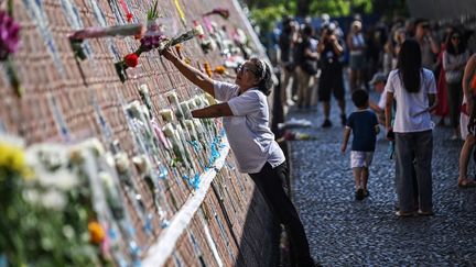 Des fleurs sont déposées sur un mur au mémorial thaïlandais de Ban Nam Khem. (LILLIAN SUWANRUMPHA / AFP)