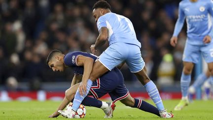 Le défenseur du PSG Achraf Hakimi en mauvaise posture sous la pression de Raheem Sterling, lors du match de Ligue des champions entre Manchester City et le PSG le 24 avril 2021. (SCOTT HEPPELL / AP)