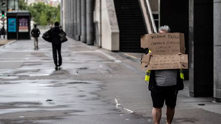 A Paris, cet homme vêtu d'un gilet jaune était seul pour porter sa pancarte, sur laquelle était notamment écrit "Nous avons droit aux miettes, nous voulons 100%". (MARTIN BUREAU / AFP)