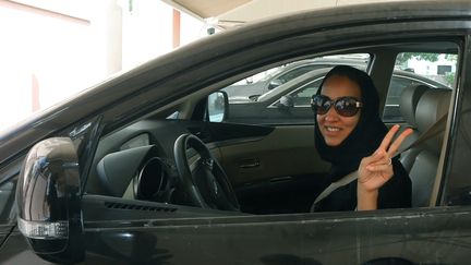 L'activiste saoudienne Manal Al Sharif, au volant d'une voiture, à Dubai, le 22 octobre 2013. (MARWAN NAAMANI / AFP)