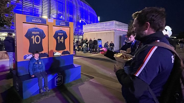 François prend son fils Lucien en photo devant le stade Pierre-Mauroy, mardi 17 octobre 2023 avant France-Ecosse. (Hortense Leblanc)