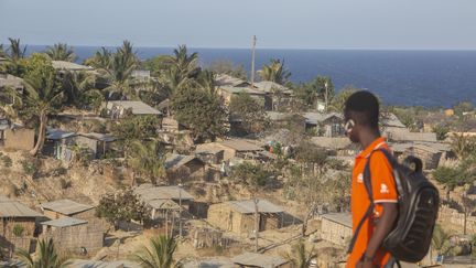 Un jeune mozambicain regarde les habitations à flanc de colline à Pemba, ville portuaire de Cabo Delgado dans le nord-est du Mozambique, en&nbsp; décembre 2020. (ALFREDO ZUNIGA / AFP)