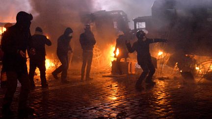 Des manifestants jettent des pierres sur les policiers, le 20 janvier 2014 &agrave; Kiev (Ukraine). (SERGEI SUPINSKY / AFP)