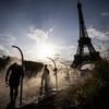 People cool off next to the Eiffel Tower in Paris on July 29, 2024. (LUIS TATO / AFP)