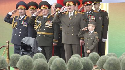 L'enfant est un passionné de la chose militaire. Alors, papa lui raconte «l’histoire de Napoléon et de la Guerre patriotique de 1812» contre l’empereur des Français. Et puis, il l’emmène à des défilés militaires, comme ici le 3 juillet 2011. Où Kolia, ceintré dans un vrai uniforme (sans la belle casquette à la soviétique), salue comme un vrai militaire. Lors de tels évènements, le bambin apprécie que les généraux le saluent à leur tour, nous explique «The Economist».  (REUTERS - BelTA - Nikolai Petrov)