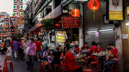 Des familles dînent dans un quartier de Bangkok (Thaïlande), le 1er février 2022.&nbsp; (JACK TAYLOR / AFP)