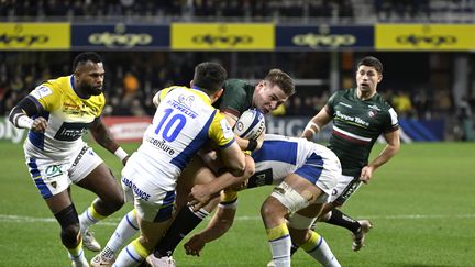 Les joueurs clermontois plaquent l'Anglais Freddie Steward, lors du match de Champions Cup entre Clermont et Leicester, le 13 janvier 2023 au stade Marcel-Michelin. (THIERRY ZOCCOLAN / AFP)