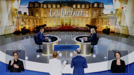 Emmanuel Macron et Marine Le Pen sur le plateau du débat d'entre-deux-tours de l'élection présidentielle 2022, diffusé par France 2 et TF1, le 20 avril 2022. (ISA HARSIN / SIPA)