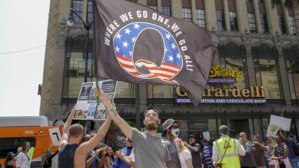 Un manifestant brandit un drapeau à la gloire&nbsp;du mouvement&nbsp;QAnon, le 22 août 2020, à Los Angeles (Etats-Unis). (KYLE GRILLOT / AFP)