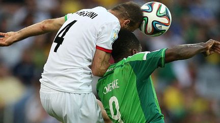 Le défenseur iranien Jalal Hosseini à la lutte avec le joueur nigérian Emmanuel Emenike