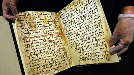 Une conservatrice de l'universit&eacute; de Birmingham (Royaume-Uni) montre, le 22 juillet 2015, de tr&egrave;s anciens fragments du Coran, retrouv&eacute;s dans la biblioth&egrave;que de l'&eacute;tablissement. (PAUL ELLIS / AFP)