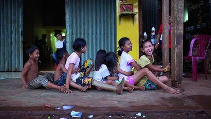 Kanha joue avec ses amis devant la maison familiale près de Memot, au Cambodge, où elle séjourne durant les vacances scolaires. (Nicolas Axelrod / Handicap International)