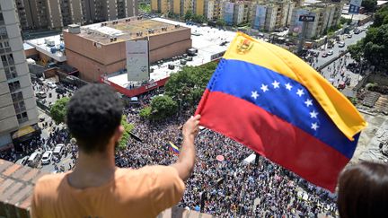 Een man zwaait met de Venezolaanse vlag vanaf een balkon tijdens een oppositiedemonstratie tegen Nicolas Maduro, op 17 augustus 2024, in Caracas, Venezuela. (Juan Barreto/AFP)