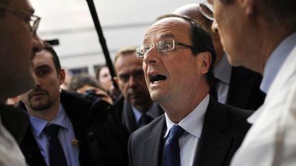 Le candidat socialiste &agrave; l'&eacute;lection pr&eacute;sidentielle Fran&ccedil;ois Hollande discute avec le personnel m&eacute;dical lors de sa visite de l'h&ocirc;pital Robert Debr&eacute; &agrave; Paris, le 2 f&eacute;vrier 2012. (FRED DUFOUR / REUTERS)