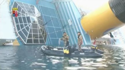 Un plongeur militaire italien se jette &agrave; l'eau pour explorer l'&eacute;pave du Concordia, le 24 janvier 2012. (FTVi / APTN)