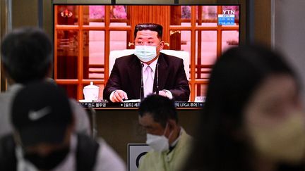 Des personnes regardent le&nbsp;leader&nbsp;nord-coréen Kim Jong-un&nbsp;parler à la télévision, le 12 mai 2022, depuis Séoul (Corée du Sud). (ANTHONY WALLACE / AFP)