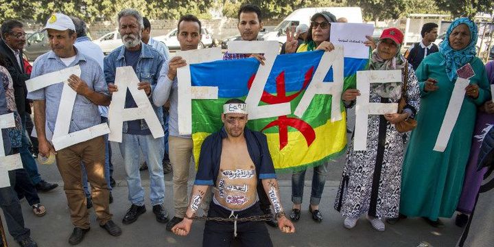 Les partisans du mouvement marocain Al-Hirak al-Shaabi brandissent des pancartes et des slogans appelant à la libération du leader du mouvement Nasser Zefzafi devant la Cour d'appel de Casablanca lors de son procès le 24 octobre 2017.  (Fadel Senna/AFP)