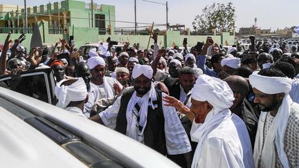 Sadeq al-Mahdi, au premier plan, ancien Premier ministre soudanais et chef du parti de l'opposition al-Oumma, salue ses partisans alors qu'il quitte une mosquée lors d'une manifestation à Omdourman, la ville jumelle de la capitale, Khartoum, le 25 janvier 2019. (- / AFP)