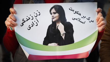 Une pancarte présentant Mahsa Amini,&nbsp;une Kurde iranienne de 22 ans&nbsp;morte trois jours après son arrestation par la police des moeurs&nbsp;en Iran, lors d'une manifestation à Varsovie (Pologne), le 6 novembre 2022.&nbsp; (STR / NURPHOTO / AFP)