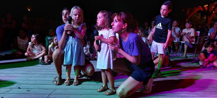 Des enfants et&nbsp;des animateurs du camping Oyam de Bidart (Pyrénées-Atlantiques) lors d'un karaoké,&nbsp;en juillet 2022. (BENJAMIN ILLY / RADIO FRANCE)