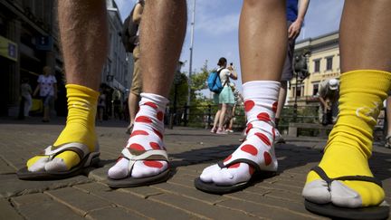 Le style n'est pas forc&eacute;ment l'apanage principal du supporter de v&eacute;lo. Malgr&eacute; les 30 degr&eacute;s qui r&eacute;gnaient le 5 juillet &agrave; Utrecht (Pays-Bas), ces fans ont tenu &agrave; porter leurs chaussettes aux couleurs du maillot jaune et du maillot &agrave; pois avec des tongs. (STIJN RADEMAKER / HOLLANDSE / SIPA)