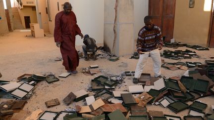 Des hommes au milieu de manuscrits br&ucirc;l&eacute;s, &agrave; l'Institut Ahmed Baba de Tombouctou (Mali), le 29 janvier 2013.&nbsp; (ERIC FEFERBERG / AFP)