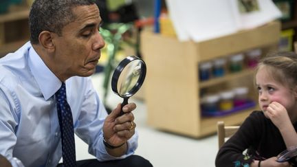 Le pr&eacute;sident am&eacute;ricain, Barack Obama, joue avec une loupe lors de sa visite d'une &eacute;cole &agrave; Decatur (G&eacute;orgie, Etats-Unis), le 14 f&eacute;vrier 2013. (BRENDAN SMIALOWSKI / AFP)