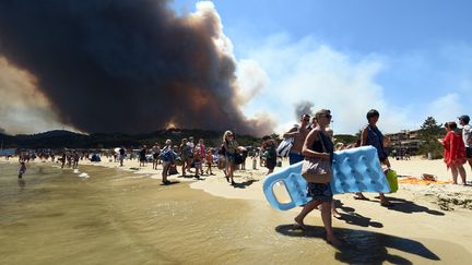 Des vacanciers quittent une plage de Bormes-les-Mimosas, le 26 juillet 2017. (ANNE-CHRISTINE POUJOULAT / AFP)