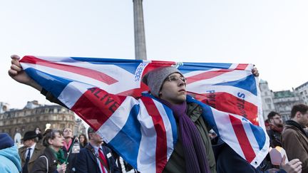 Un homme brandit le drapeau du Royaume-Uni, à Trafalgar Square, à Londres, le 23 mars 2017,&nbsp;au lendemain de l'attentat qui a frappé la capitale britannique.&nbsp; (JOEL FORD / AFP)