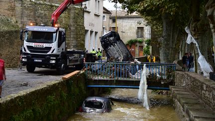 Des voitures sont extraites d'une rivière, le 15 octobre 2018, à Villegailhenc (Aude). (PASCAL PAVANI / AFP)