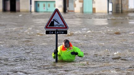 Un sauveteur au pied d'un panneau de signalisation &agrave; Quimperl&eacute; (Finist&egrave;re), le 7 f&eacute;vrier 2014, pendant un crue de la La&iuml;ta. (FRANK PERRY / AFP)