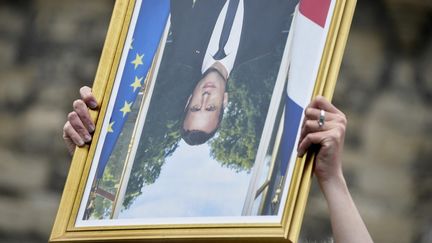 Un manifestant brandit un portrait du président français Emmanuel Macron à l'envers lors d'une "Marche pour le climat" à Nantes (Loire-Atlantique), le 9 mai 2021. (SEBASTIEN SALOM-GOMIS / AFP)