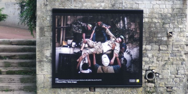 La photo réalisée par E. Elias : un combattant de l'armée syrienne libre, blessé, est transporté à l'abri dans la vieille citadelle d'Alep, le 20 août 2012 (Chrystel Chabert)