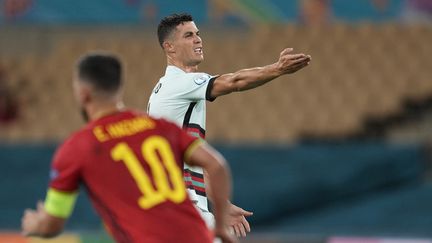 La star de la sélection du Portugal, Cristiano Ronaldo, mécontent lors du huitième de finale de l'Euro 2021 contre la Belgique d'Eden Hazard, le 27 juin 2021 à Seville. (THANASSIS STAVRAKIS / POOL / AFP)