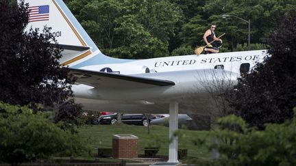 Un employ&eacute; nettoie un avion expos&eacute; devant le terminal pour voyageurs de l'Andrews Air Force Base, dans le Maryland (Etats-Unis), le 24 juillet 2013. (BRENDAN SMIALOWSKI / AFP)