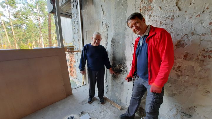 Dimitri et son papa, Valéri, dans ce qui était la cuisine de l'appartement, le 2 octobre 2022. (AGATHE MAHUET / FRANCEINFO)