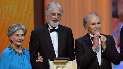 Le r&eacute;alisateur autrichien&nbsp;Michael Haneke, entour&eacute; de ses acteurs Emmanuelle Riva et Jean-Louis Trintignant, re&ccedil;oit la Palme d'or pour "Amour", &agrave; Cannes, le 27 mai 2012. (ALBERTO PIZZOLI / AFP)