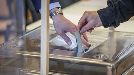 Une personne vote pour le premier tour de l'élection présidentielle, le 10 avril 2022, dans un bureau de vote du 15e arrondissement de Paris.&nbsp; (FRED DUGIT / MAXPPP)