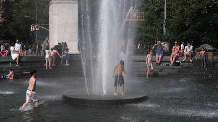 Des enfants et des adultes tentent de se rafraîchir dans une fontaine à New York, le 19 juillet 2019. (SPENCER PLATT / GETTY IMAGES NORTH AMERICA / AFP)