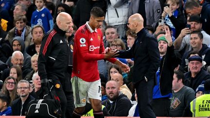 Erik ten Hag (droite) console Raphaël Varane lors de sa sortie sur blessure face à Chelsea, le 22 octobre 2022. (GLYN KIRK / IKIMAGES / AFP)