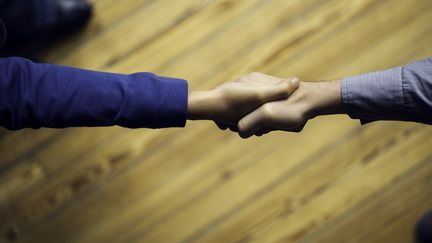 Une poignée de mains entre deux personnes. (FREDERIC CIROU / MAXPPP)