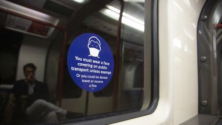 Une affiche pour le port du masque dans les transports en commun à Londres, le 19 janvier 2022. (RASID NECATI ASLIM / ANADOLU AGENCY / AFP)