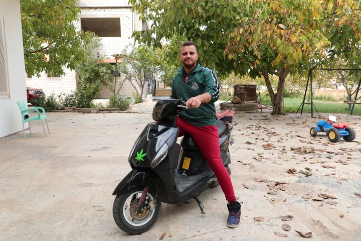 Rabeh Shemaly sur son scooter, dans la cour de sa maison à&nbsp;El Marj au Liban, le 30 octobre 2021. (PIERRE-LOUIS CARON / FRANCEINFO)