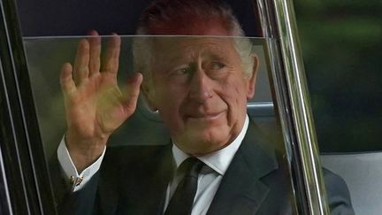 Le roi Charles III de Grande-Bretagne salue la foule le 14 septembre 2022, avant la procession cérémonielle du cercueil de la reine Elizabeth II, du palais de Buckingham à Westminster Hall (STEFAN ROUSSEAU / POOL)